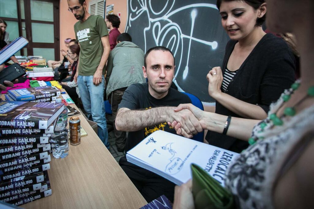 Universita' di Ingegneria di Pisa. Zerocalcare incontra gli studenti. Nella foto Michele Rech firma una copia del fumetto Kobane Calling